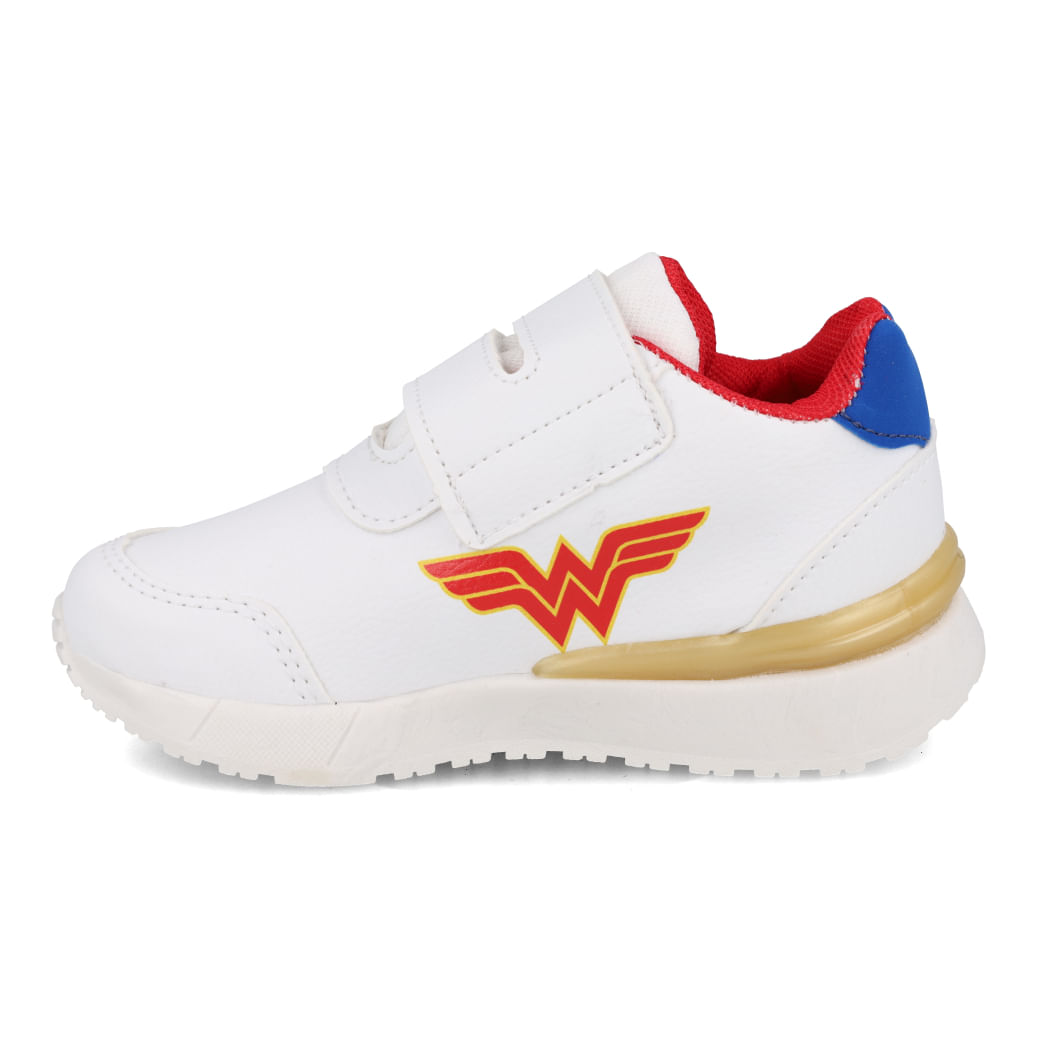 Tênis infantil branco com detalhes coloridos e logo da Mulher Maravilha, vista lateral com fechamento em velcro.